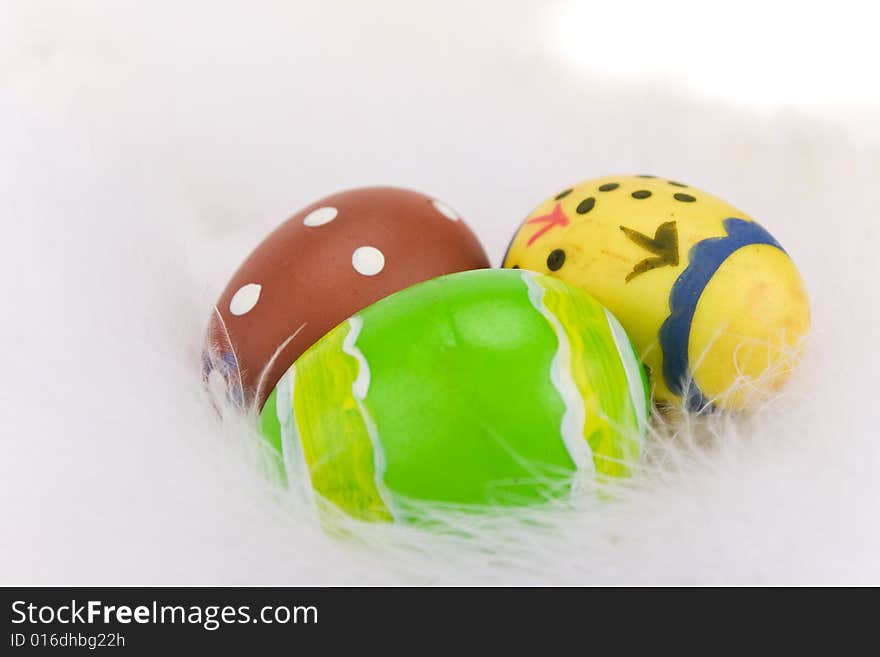 Colorful Easter eggs isolated on a white feathers