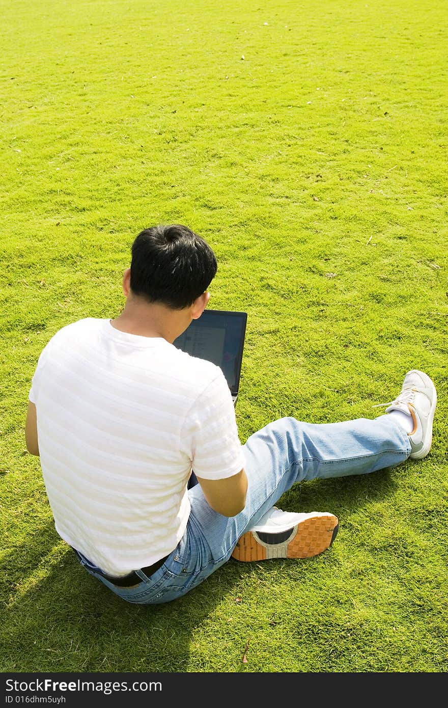 A young man using a laptop outdoors