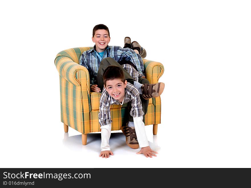 Two young happy smiling boys playing in the chair. Two young happy smiling boys playing in the chair