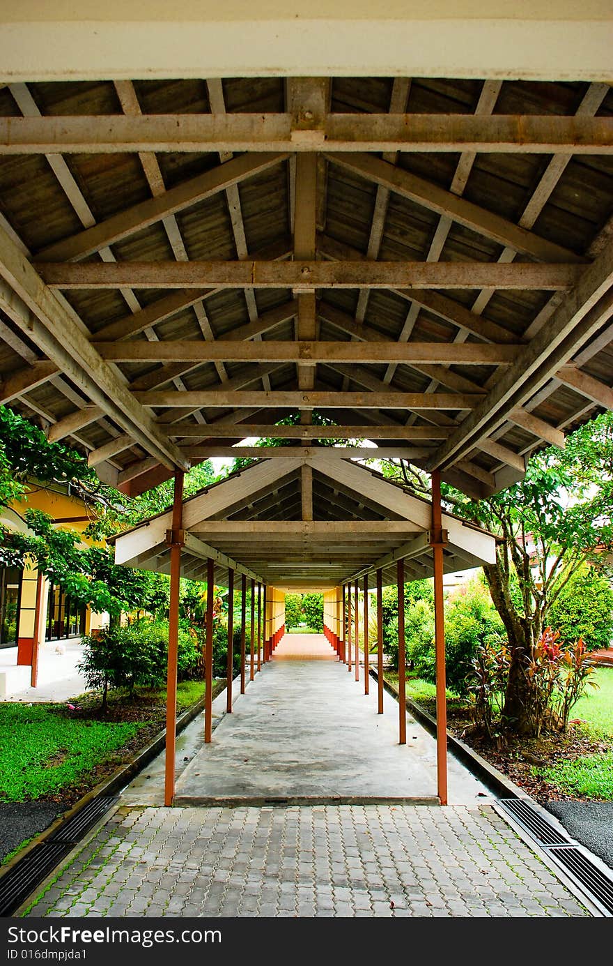 A walkway that crosses through a garden, with wooden beams. A walkway that crosses through a garden, with wooden beams