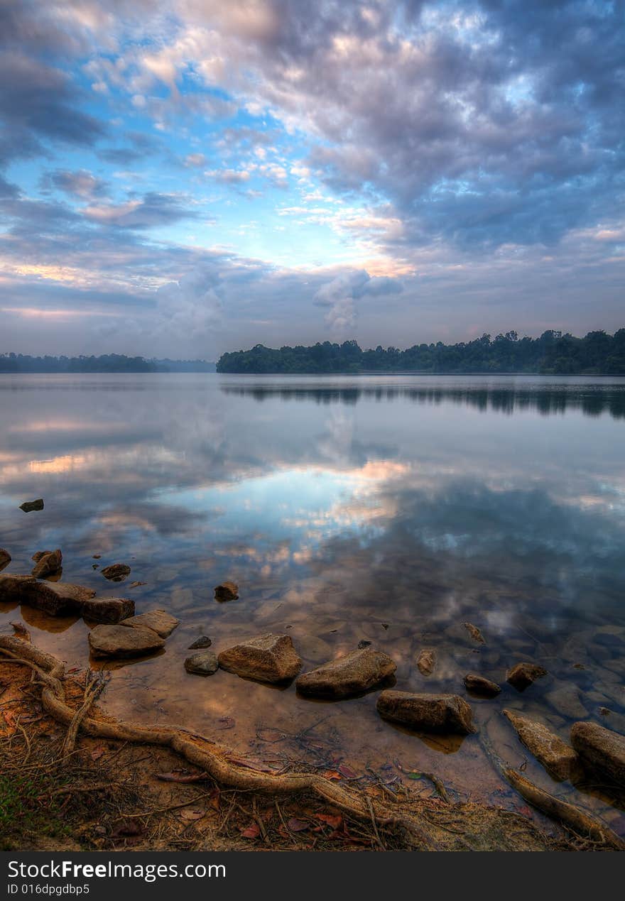 Cloudfilled skies in the morning over a lake. Cloudfilled skies in the morning over a lake