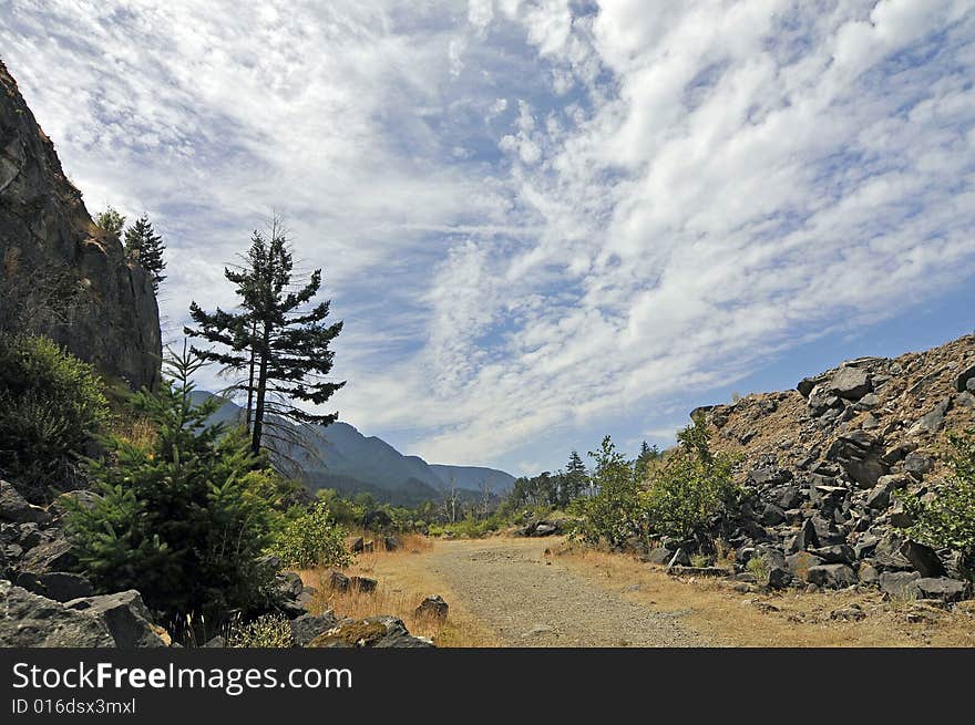 Road to the river with clear blue sky and clouds