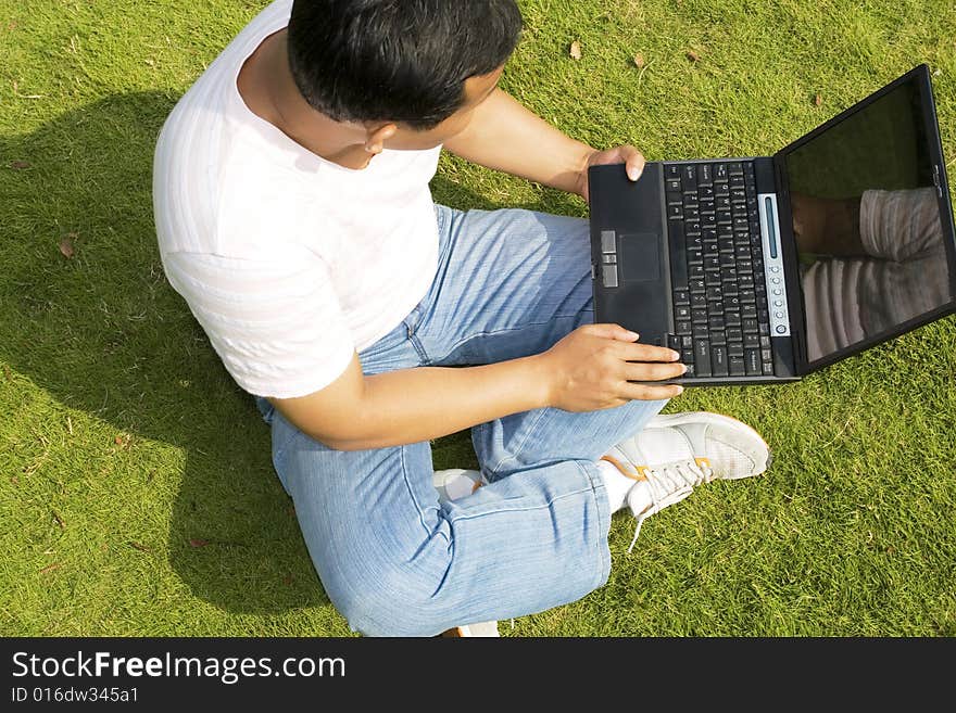 A young man using a laptop outdoors