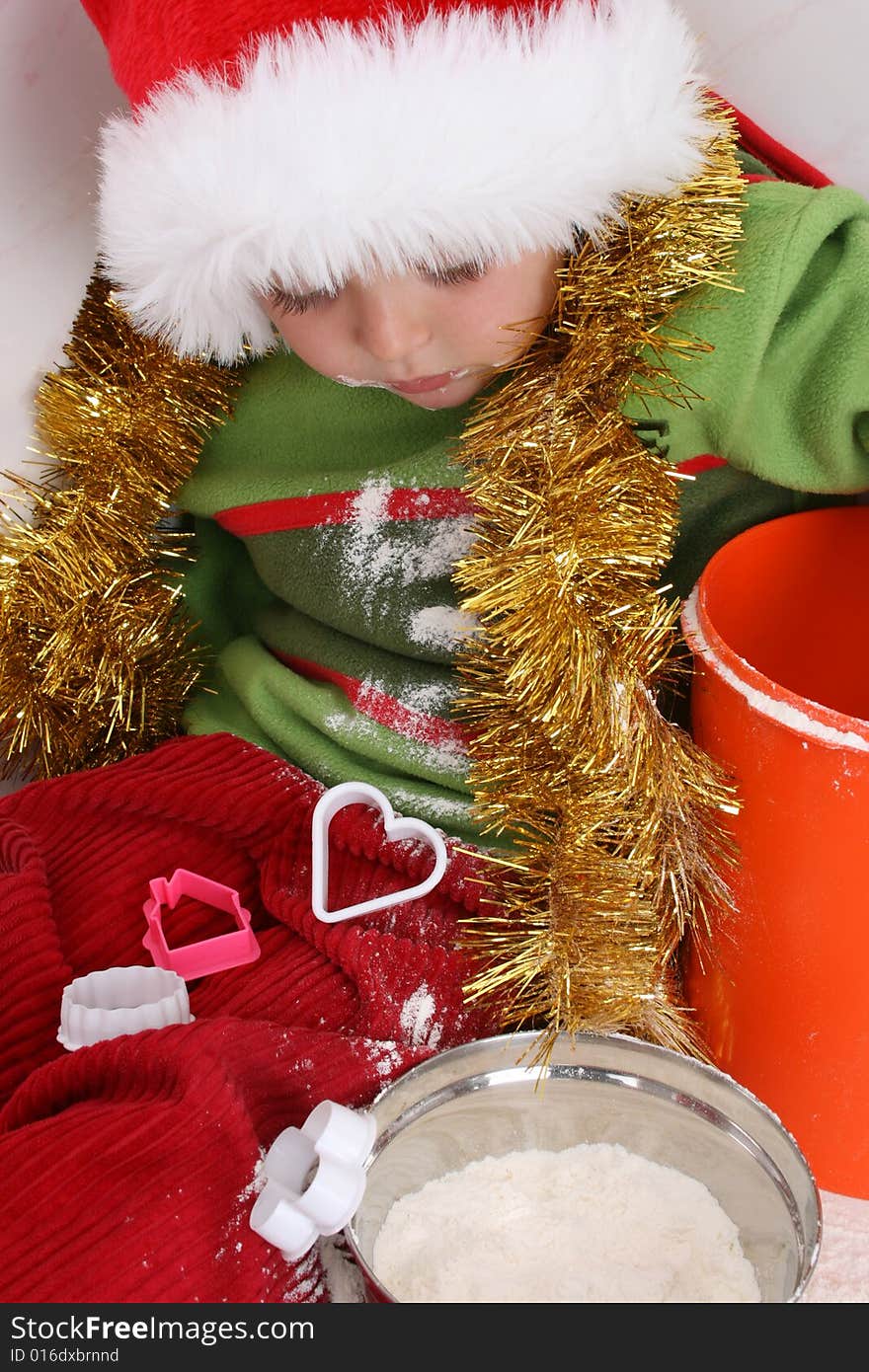 Toddler wearing a christmas hat, baking christmas cookies