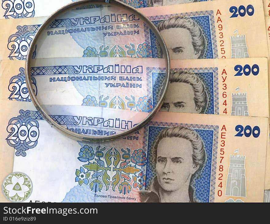 Stack of Cash under a magnifier. Stack of Cash under a magnifier