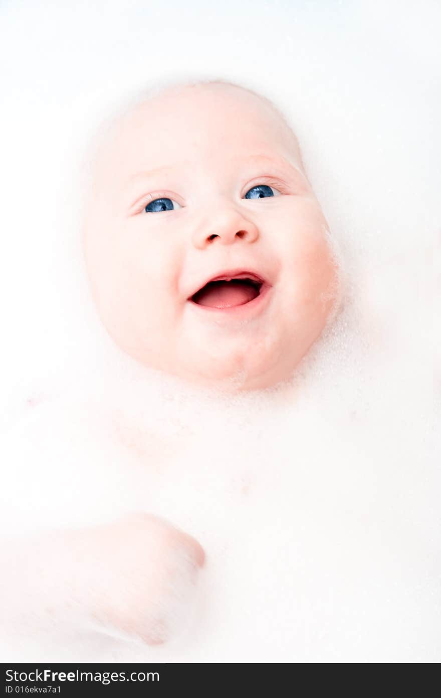 Closeup little smiling baby portrait in the bathroom. Closeup little smiling baby portrait in the bathroom