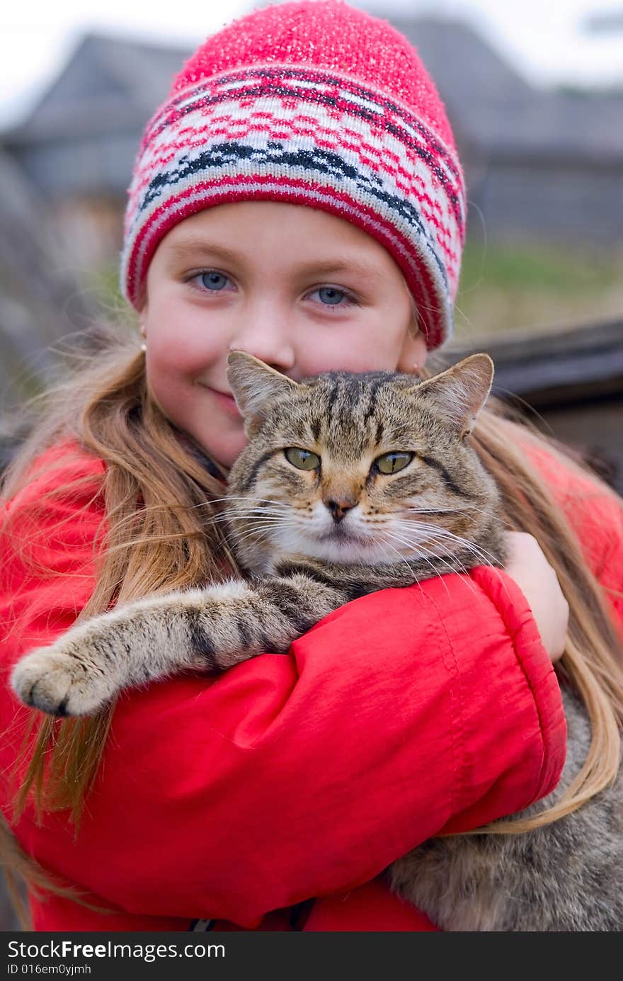 Young girl keeps gray a kitty on hand. Young girl keeps gray a kitty on hand