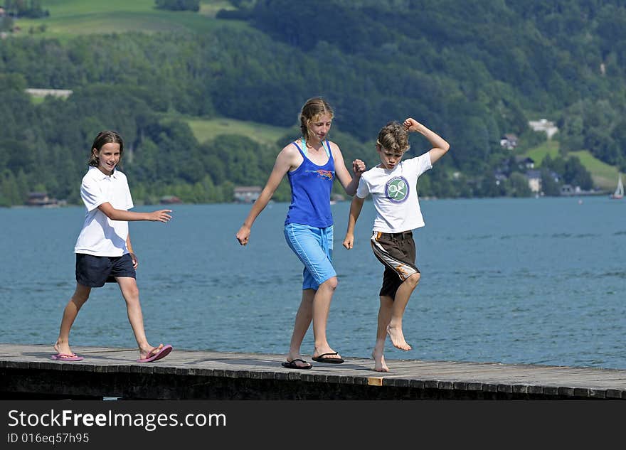 Three Children Marching Along A Pier