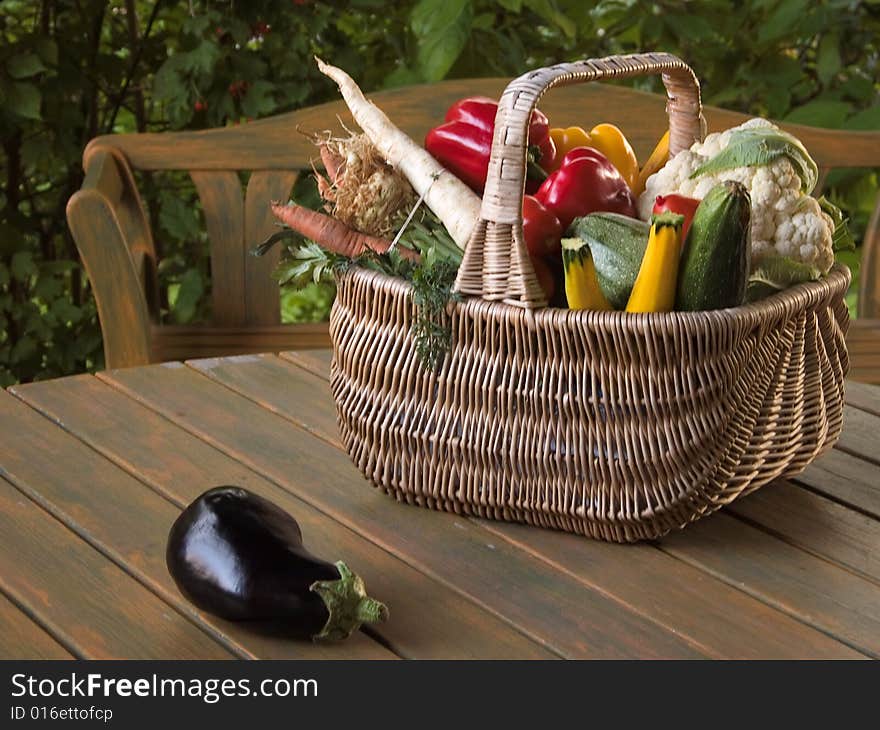 Aubergines and other vegetables in a wicker basket on the table. Aubergines and other vegetables in a wicker basket on the table.