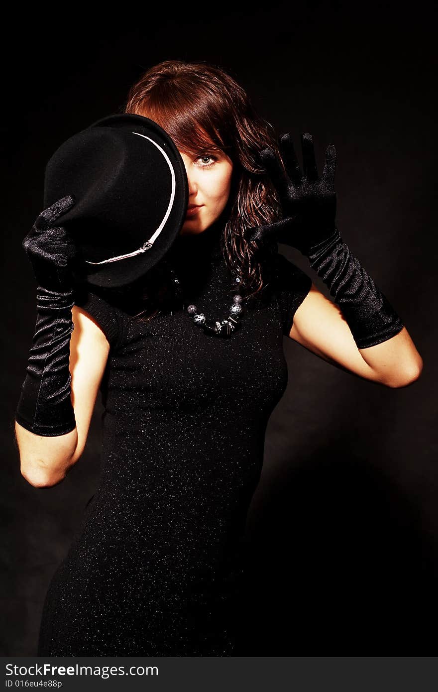 The girl in black clothes on a white background with a hat hat