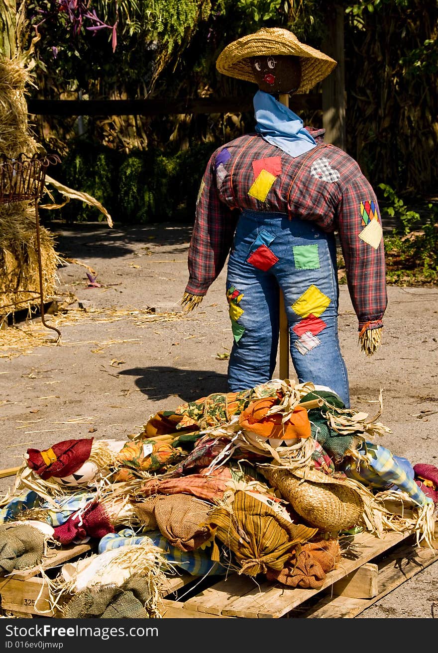 Black straw woman standing over a pile of straw dolls clothes. Black straw woman standing over a pile of straw dolls clothes