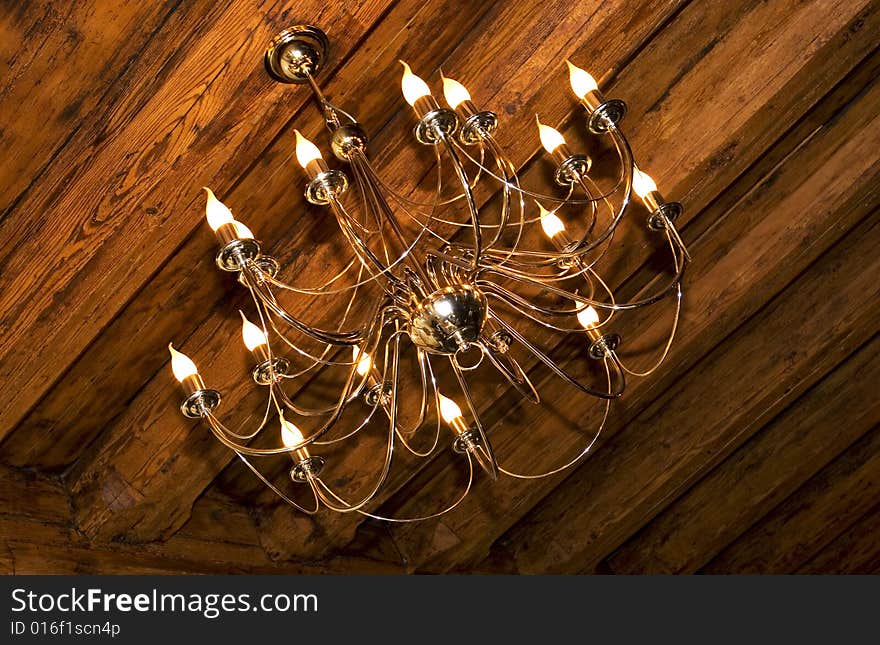 Photo of chandelier on the wooden 	ceiling