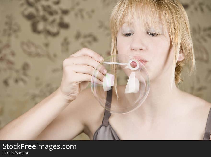 Pretty young girl with blue eyes blowing a bubble. Pretty young girl with blue eyes blowing a bubble