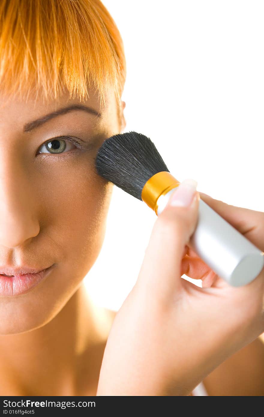 Sexy woman making her makeup. She's looking at camera. Front view. Closeup on face. Sexy woman making her makeup. She's looking at camera. Front view. Closeup on face.