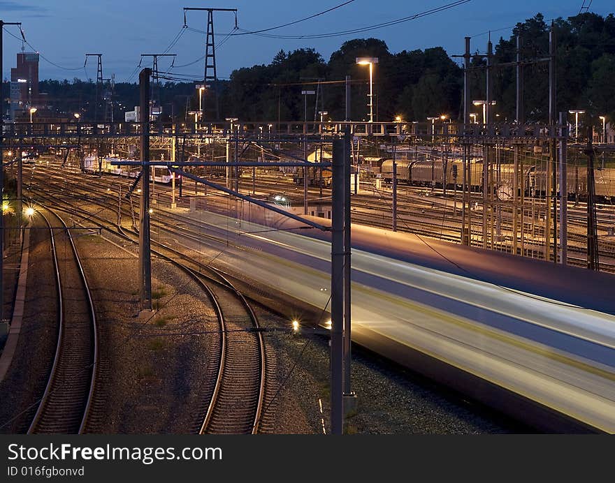 A train leaving the train station at night. A train leaving the train station at night.