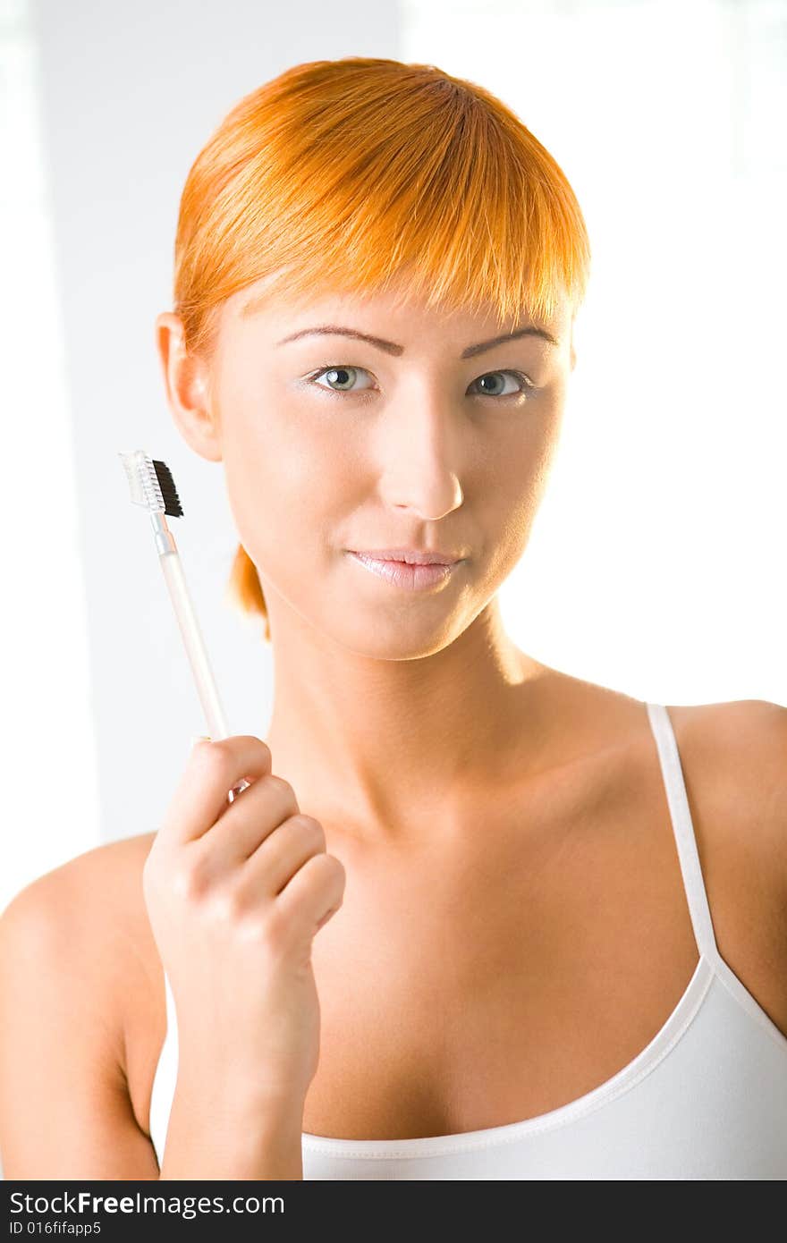 Young sexy woman with makeup brush. She's looking at camera. Front view. Young sexy woman with makeup brush. She's looking at camera. Front view.