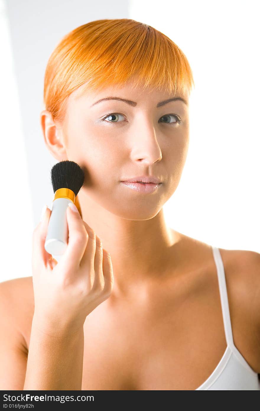 woman making her makeup. she's looking at camera. Front view. woman making her makeup. she's looking at camera. Front view.