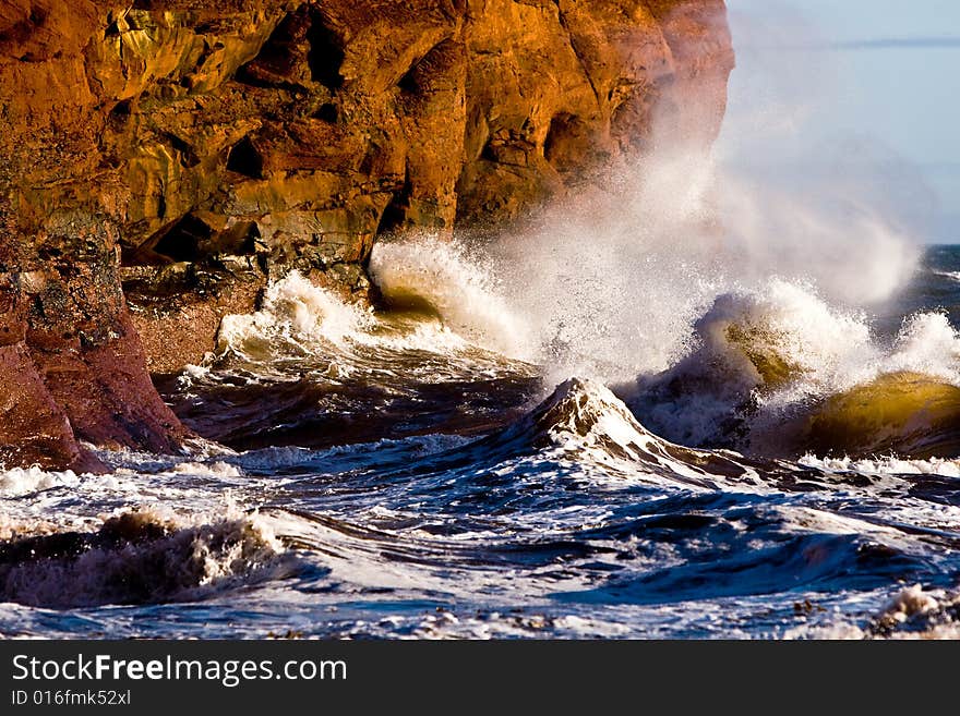 Waves hit the coast with red rocks. Waves hit the coast with red rocks