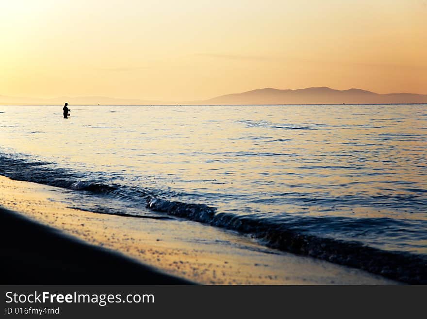 Fisherman silhouette at sunrise, Tuscany, Italy