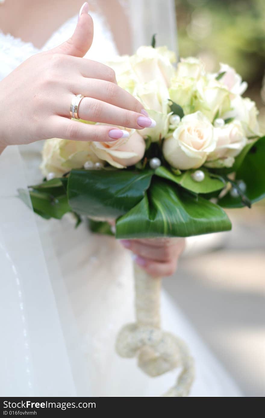 Hands of bride holding wedding bouquet with roses. Hands of bride holding wedding bouquet with roses