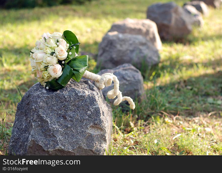 The wedding bouquet with white roses on a stone. The wedding bouquet with white roses on a stone