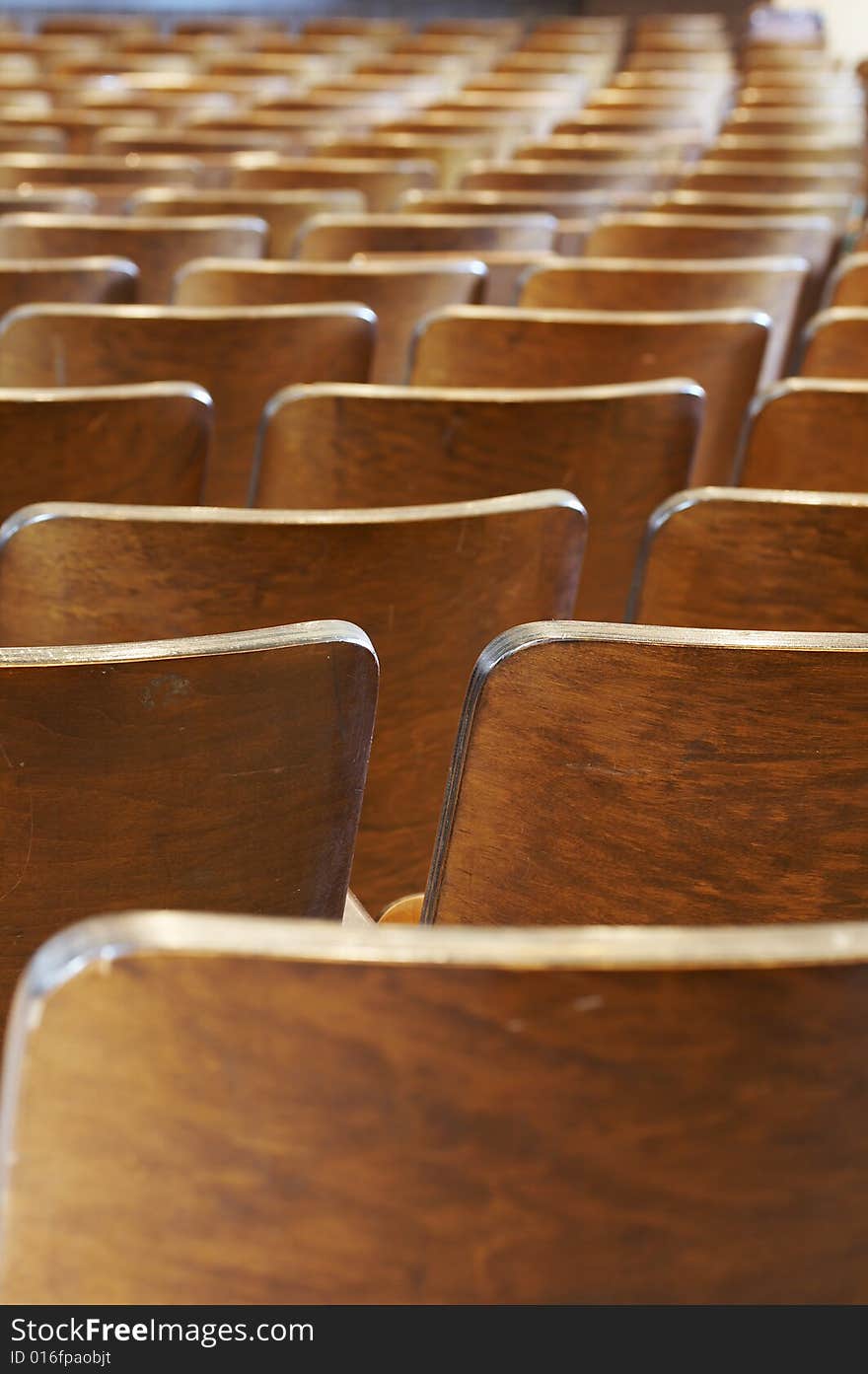 Rows of wood chairs in an old auditorium. Rows of wood chairs in an old auditorium