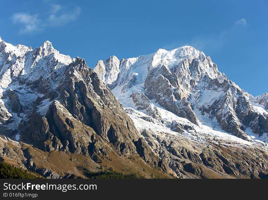 Summer view of snowcapped peaks in an alpine valley. Gran Jourasses (Mont Blanc massif), Val Veny, Courmayeur, Italy. Summer view of snowcapped peaks in an alpine valley. Gran Jourasses (Mont Blanc massif), Val Veny, Courmayeur, Italy.