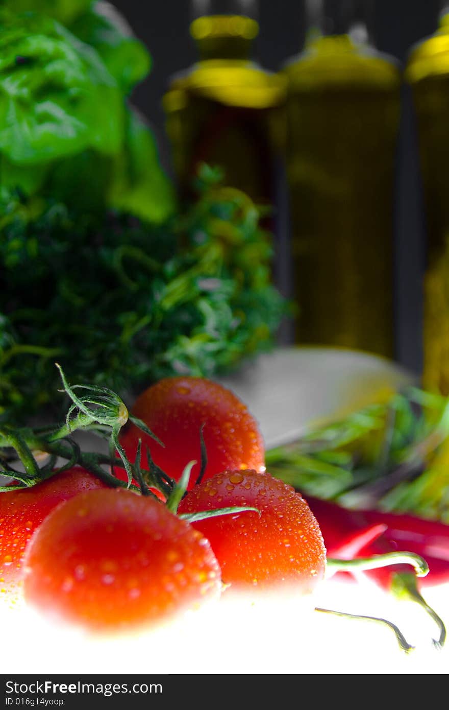 Tomatoes in front of some herbs and bottles. Tomatoes in front of some herbs and bottles