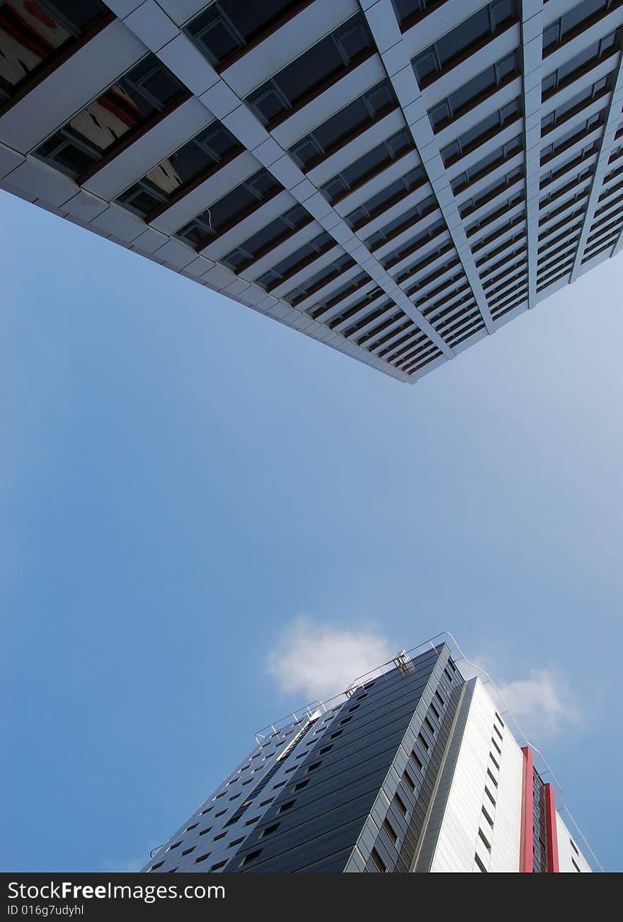 View of tower block dominating smaller office block. View of tower block dominating smaller office block