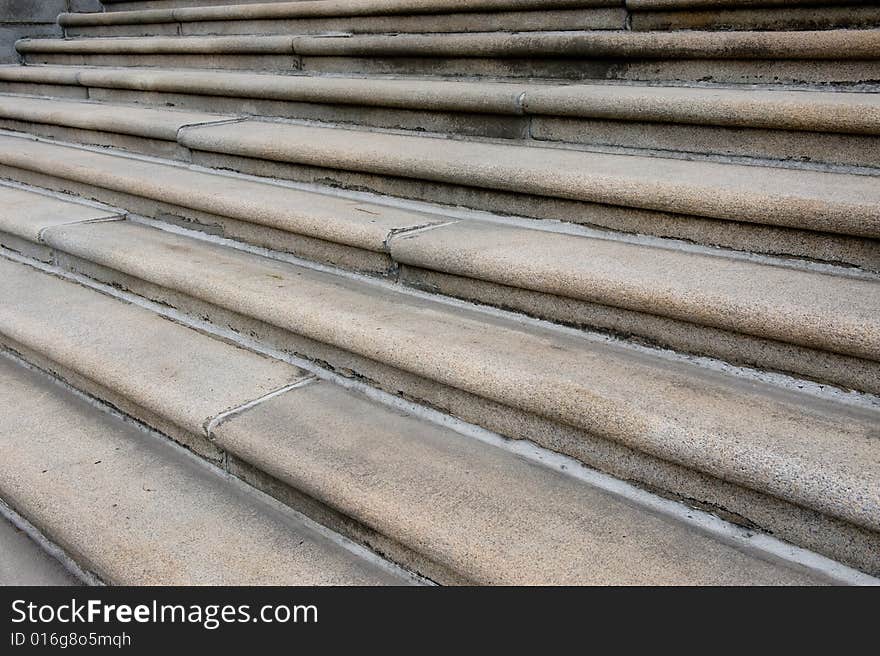 Old cement stairs with shadows, cracks, stains, and white molding