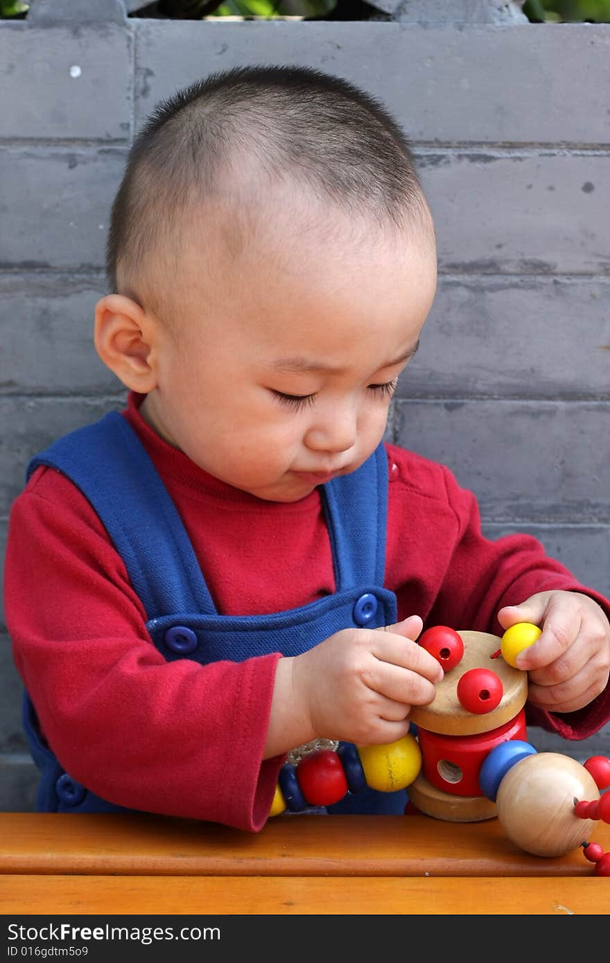 The lovable boy concentrates his toy