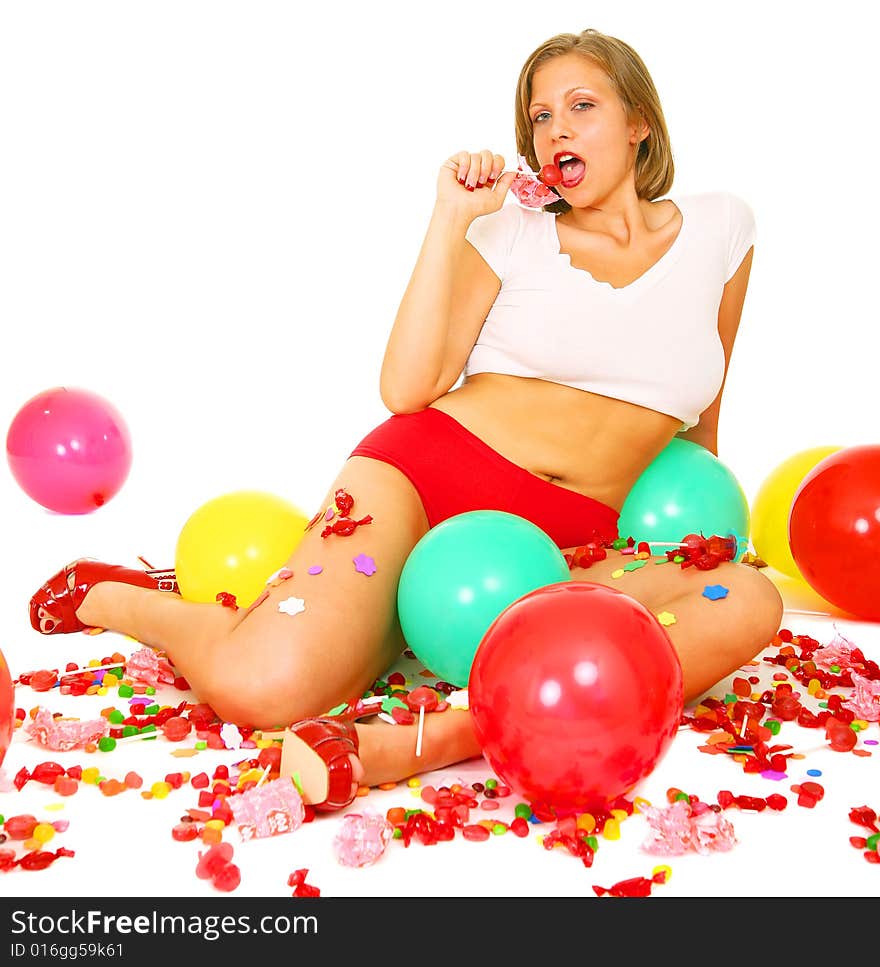 Young caucasian eating candy and surrounded by bunch of candies and balloons. Young caucasian eating candy and surrounded by bunch of candies and balloons