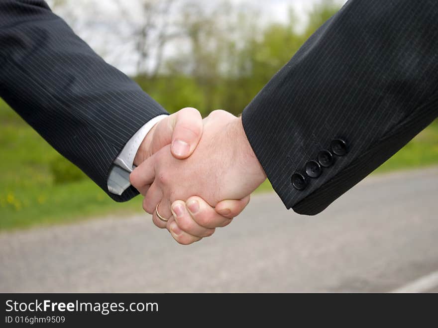 Two young businessmen shaking hands