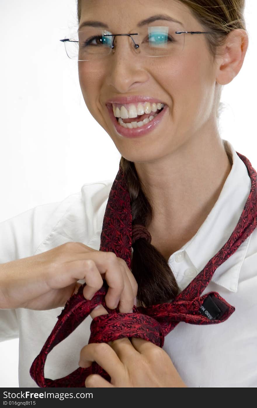 Young happy woman tying her tie against white background