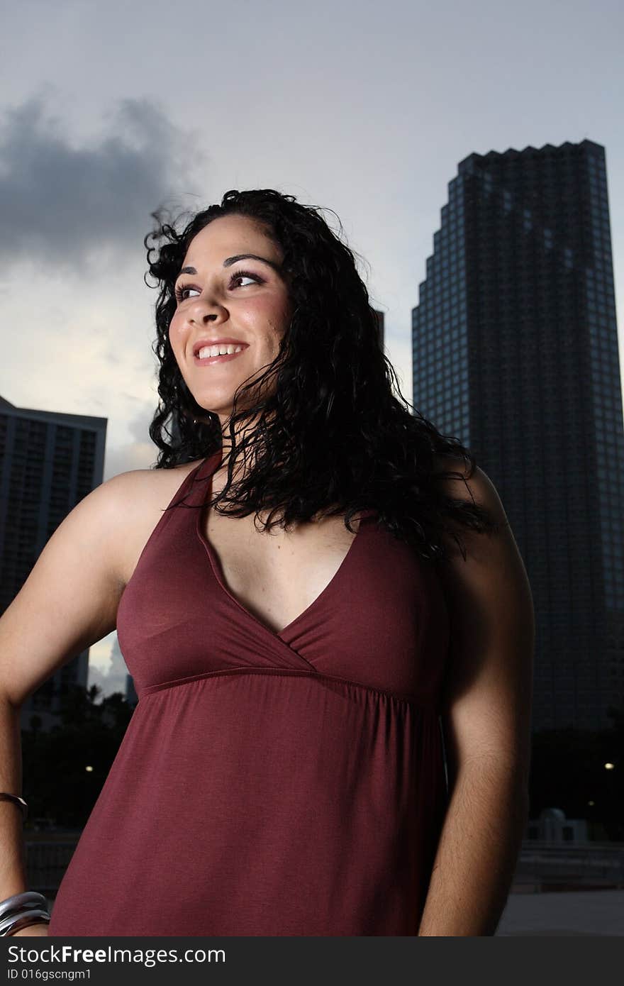 Young female posing with tall office buildings in the background. Young female posing with tall office buildings in the background.