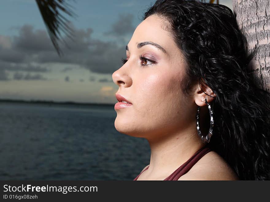 Young female looking sideways with ocean horizon in the background. Young female looking sideways with ocean horizon in the background