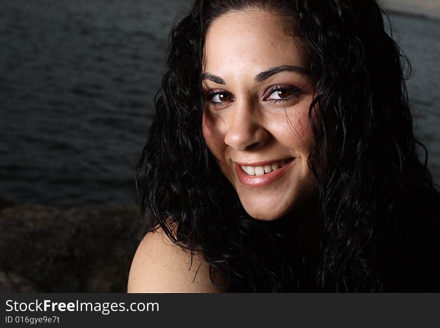 Young woman smiling with a water background. Young woman smiling with a water background