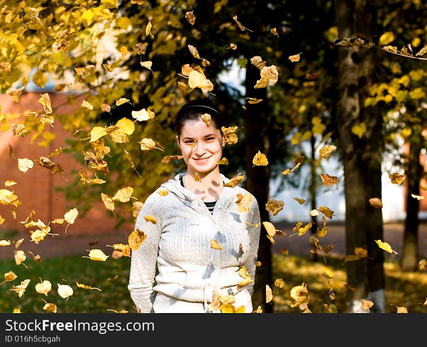 The yong woman stand in autumnal leaves. The yong woman stand in autumnal leaves