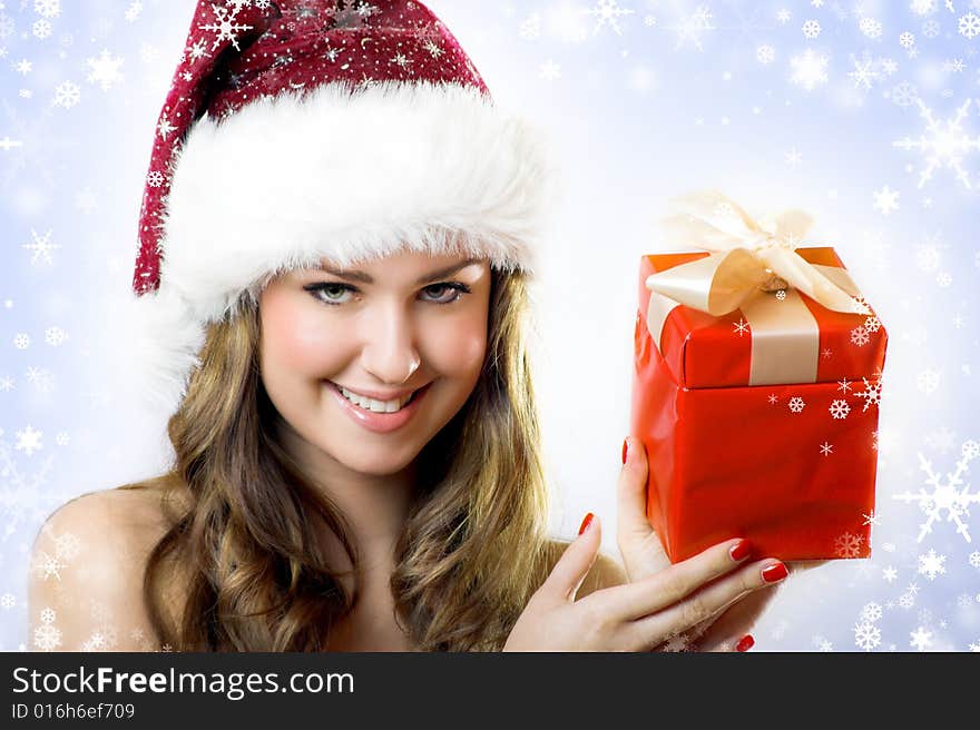 Winter portrait of a beautiful young woman with a cap  and a gift and snowflakes. Winter portrait of a beautiful young woman with a cap  and a gift and snowflakes