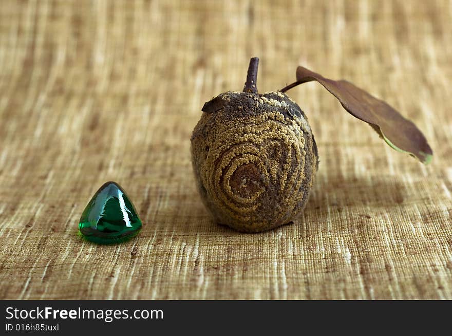 Rotten apple and glass stone close-up isolated on brown background