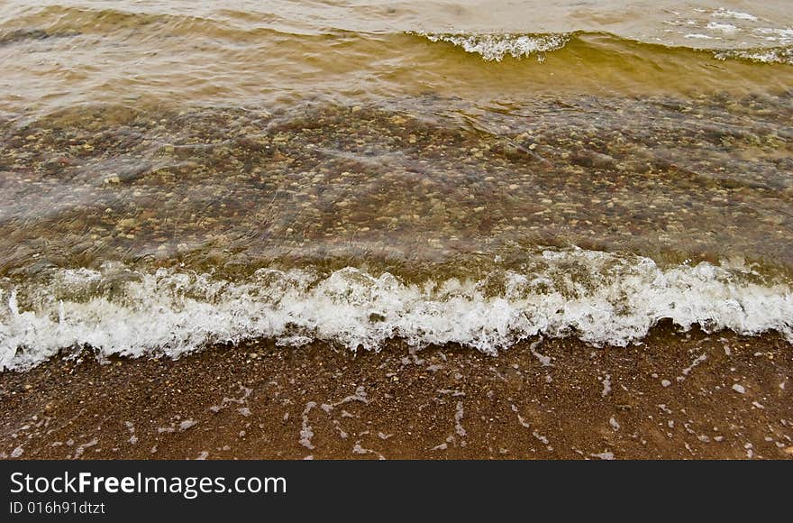 The wave runs on sandy coast. The wave runs on sandy coast