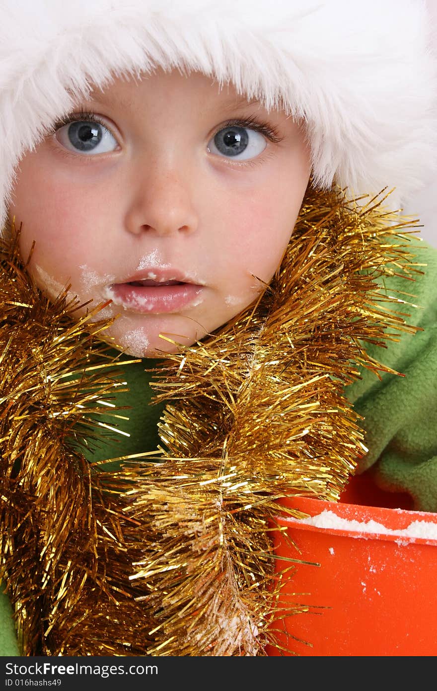 Toddler wearing a christmas hat, baking christmas cookies