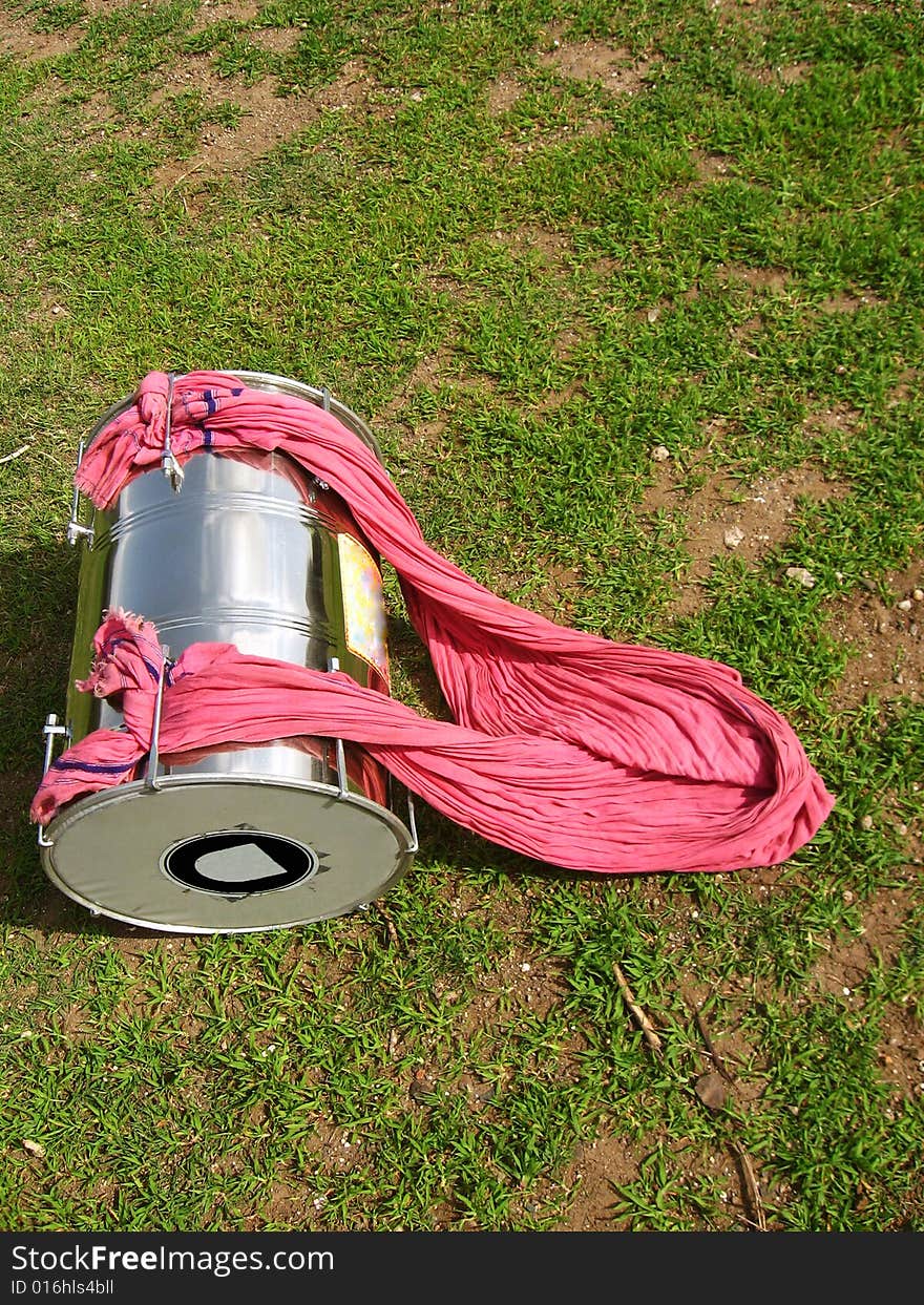 An isolated traditional single drum kept on the grass. An isolated traditional single drum kept on the grass