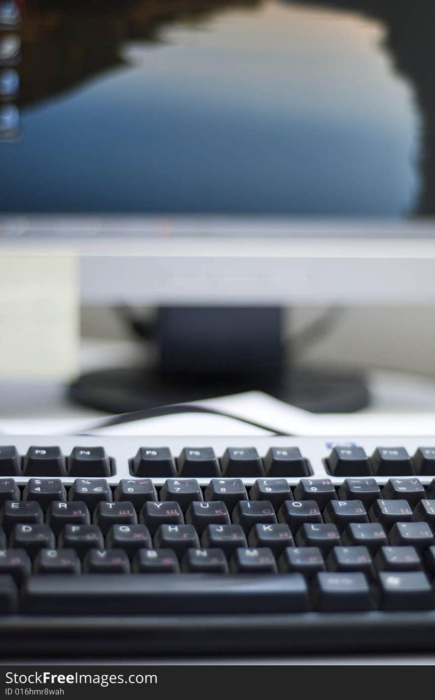 Shallow depth of field on a computer keyboard. On the background can be seen a part of the desktop LCD monitor. The focus is on the keyboard buttons.