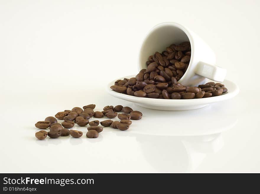 White coffee cup and coffee beans on a light background