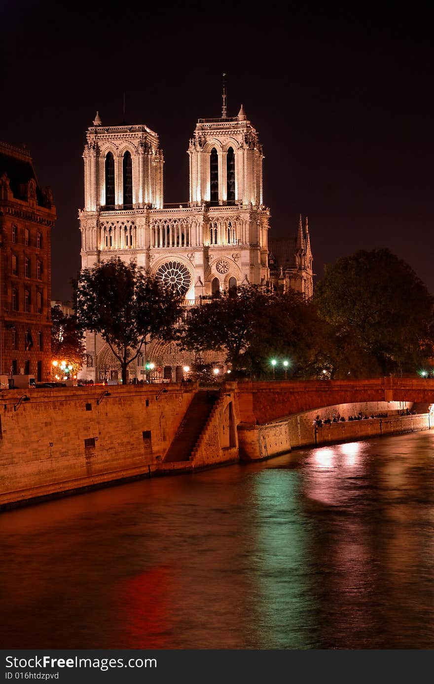 Notre Dame cathedral by night, in Paris, France, as seen from river Seine bank. Notre Dame cathedral by night, in Paris, France, as seen from river Seine bank