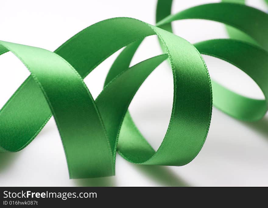 Green ribbon curling on white