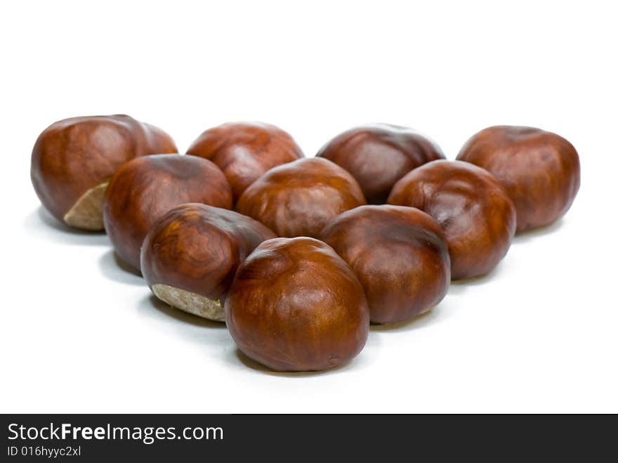 A few brown chestnuts are on a white background