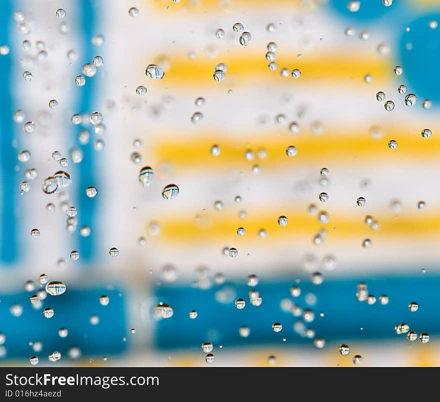 Flying drops of water on the bright coloured background