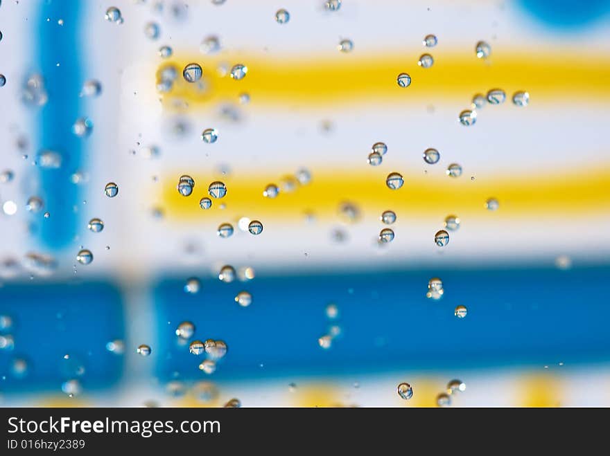 Flying drops of water on the bright coloured background